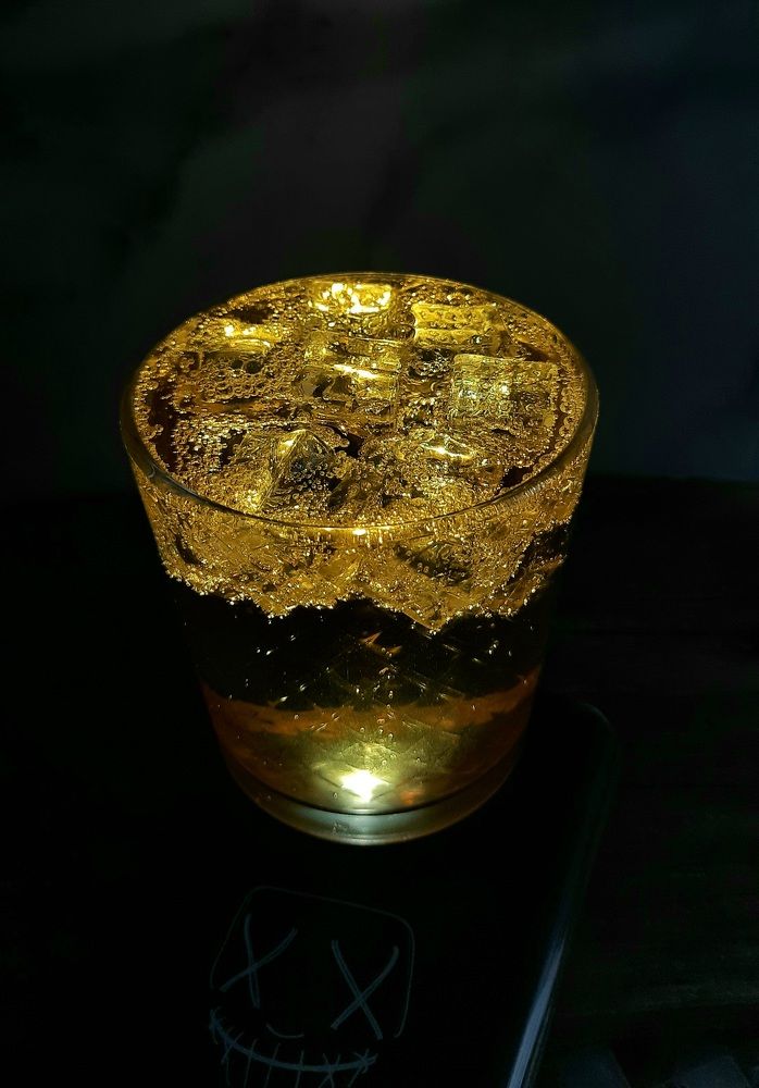 Янтарный напиток со льдом в луче