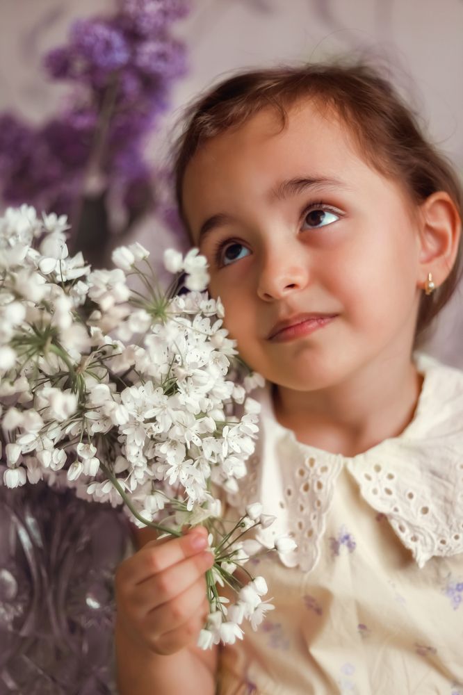 Милая девочка нюхает цветы