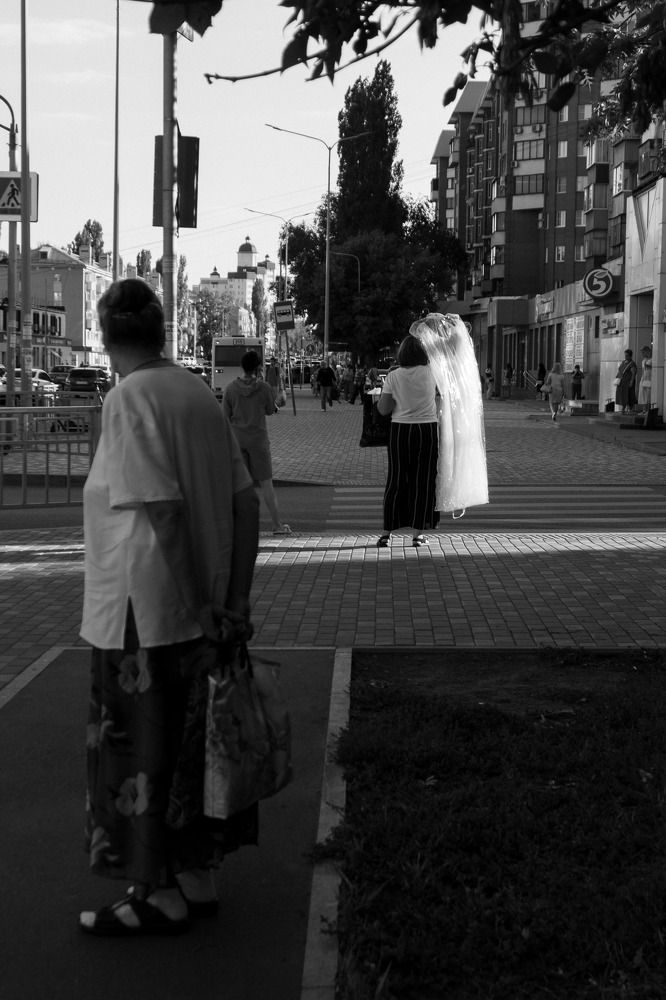 Пожилая женщина смотрит на свадебное платье