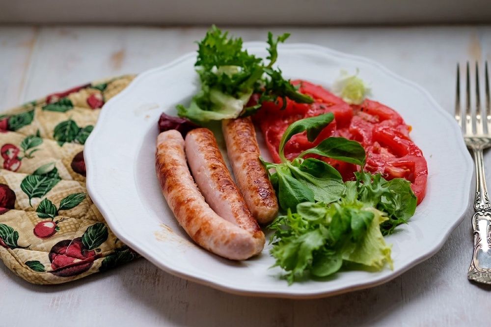 Salchichas de pollo con tomate y ensalada