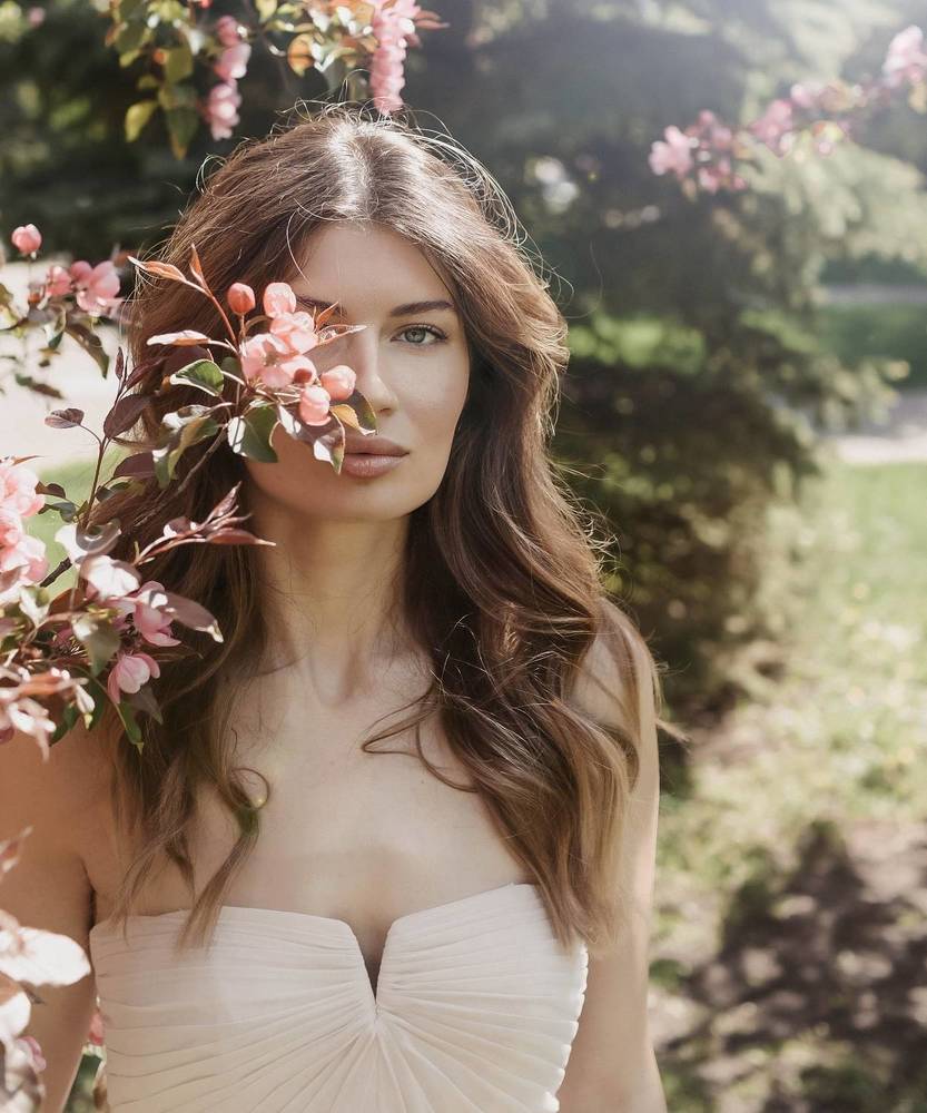 Девушка и цветущая розовая яблоня