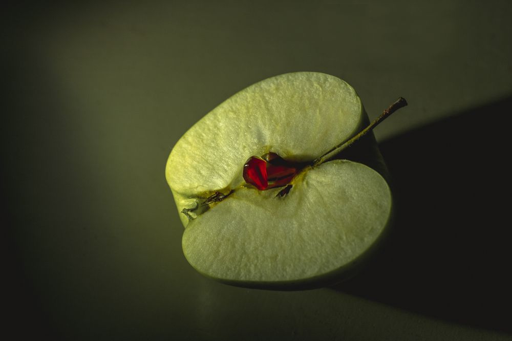 Гранатовые косточки на зелёном яблоке