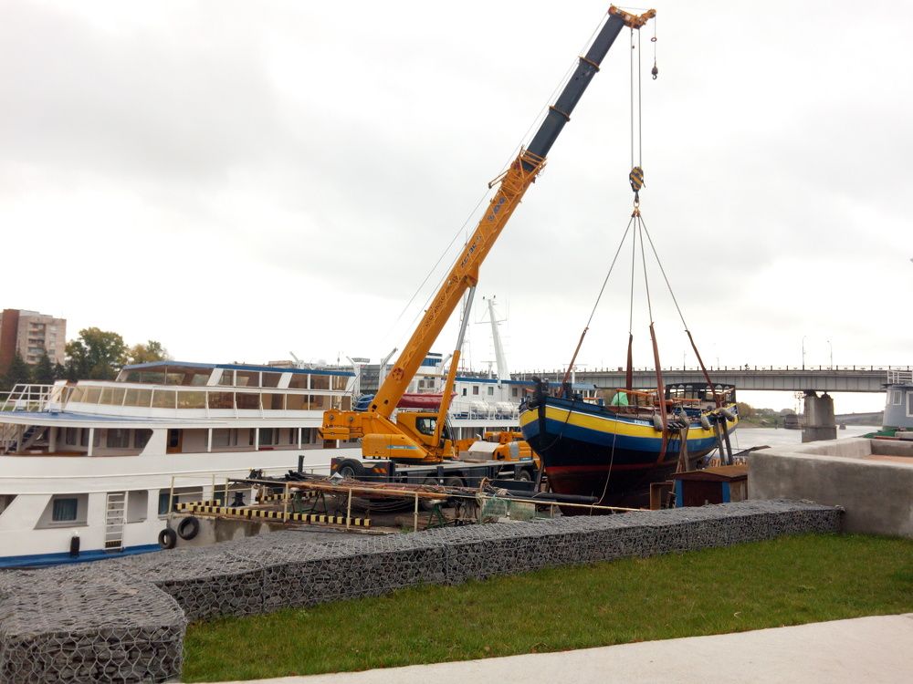 Автокран поднимает корабль