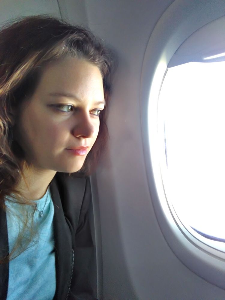 Girl looking out the window of an airplane