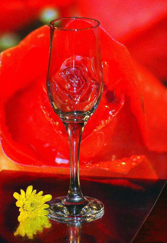 Бокал на фоне розы