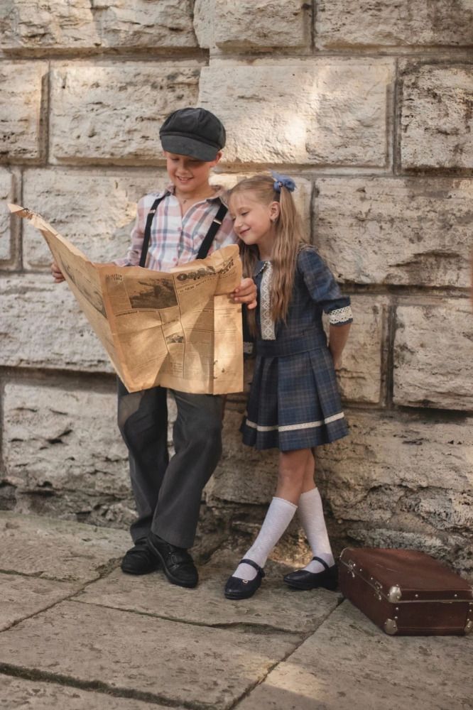 Брат и сестра читают газету.