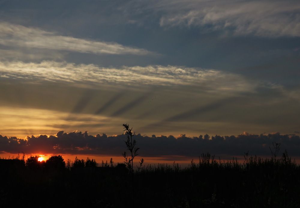 The rays of the setting sun break through the clouds