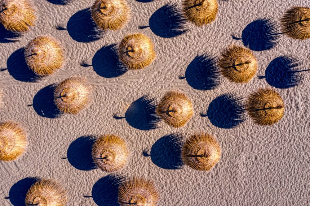 Sandy beach with reed umbrellas. Spain