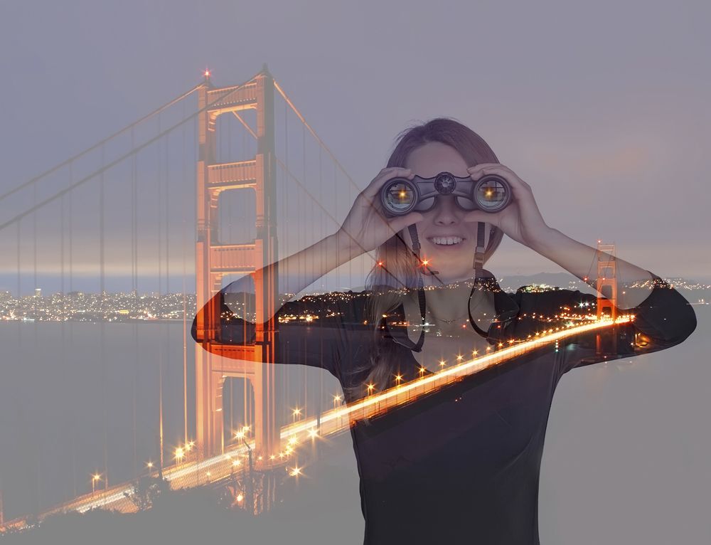 Girl with binoculars near Golden Gate Bridge in San Francisco.