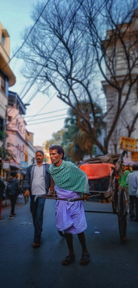 a Handpulled Rikshaw & The Rickshawpuller at his own work.