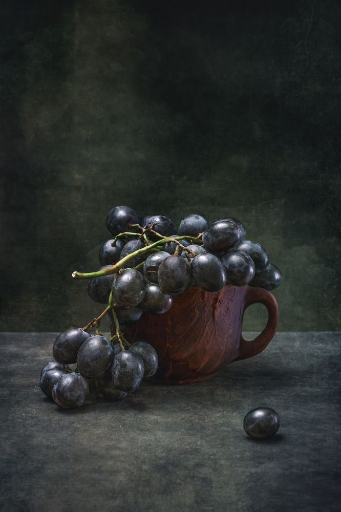 Тёмный виноград в коричневой чашке