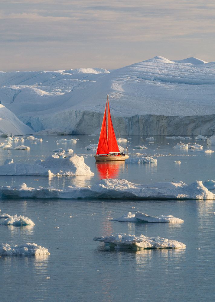 Red boat between Greenland Icebers