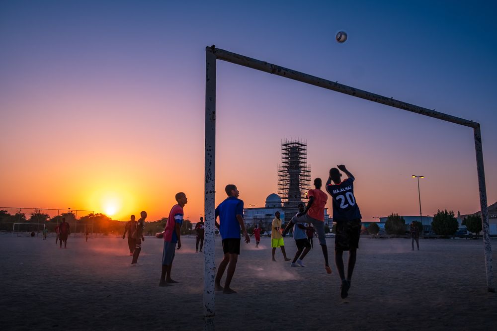 Playing football against beautiful sunset in Bahrain