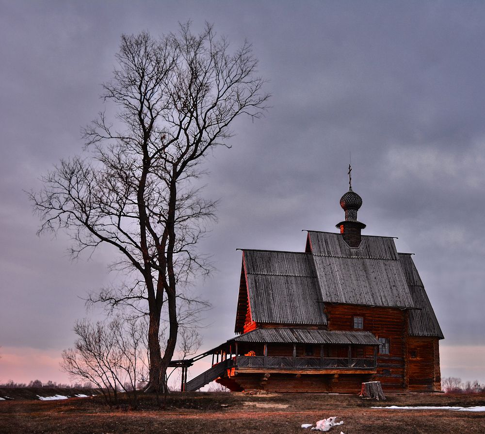 Wooden church in red rays of sunset