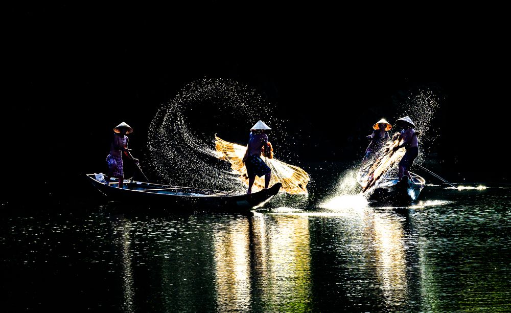 cast a net to catch fish on Nhu Y river, Hue,Vietnam.