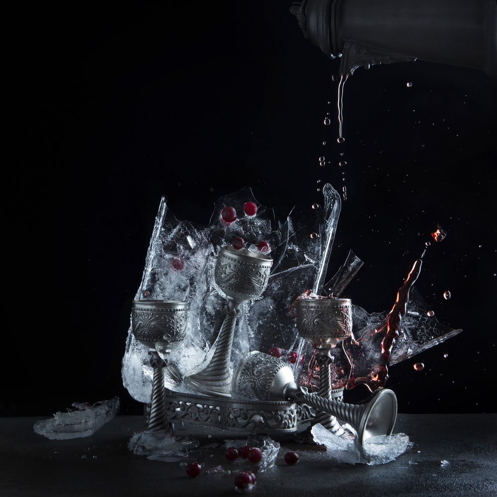 Оловянные кубки во льду с красным вином и ягодами.