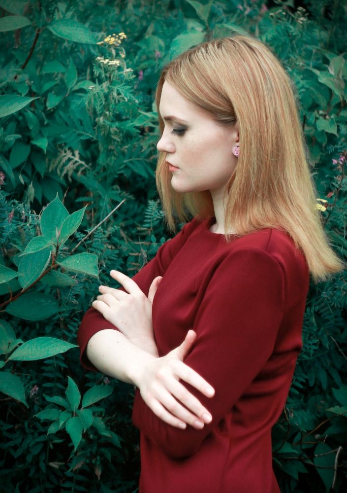Oktyabrina on the background of an ornamental shrub in profile