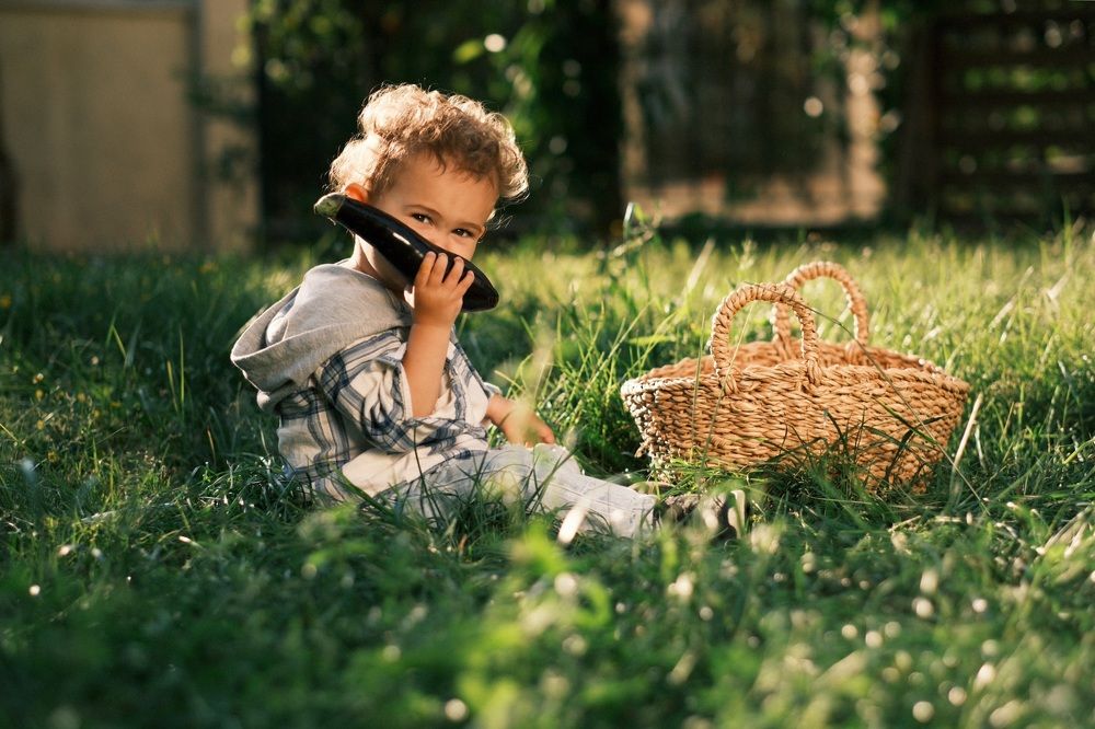 Golden-Haired Toddler with Eggplant