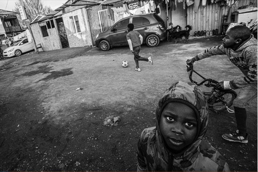 Niños migrantes juegan en campamento