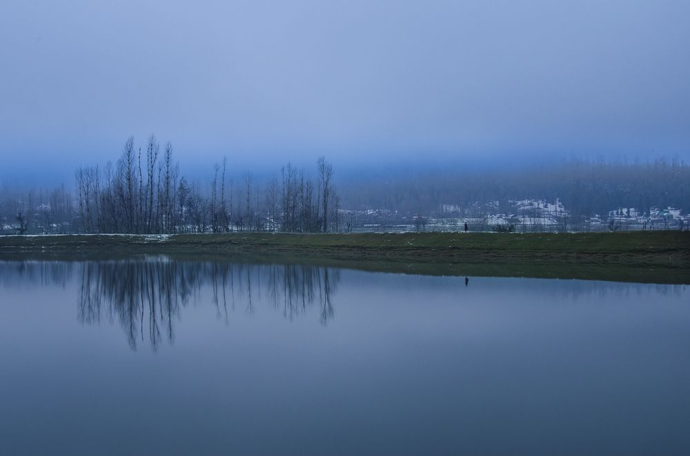Lone walker on lake side