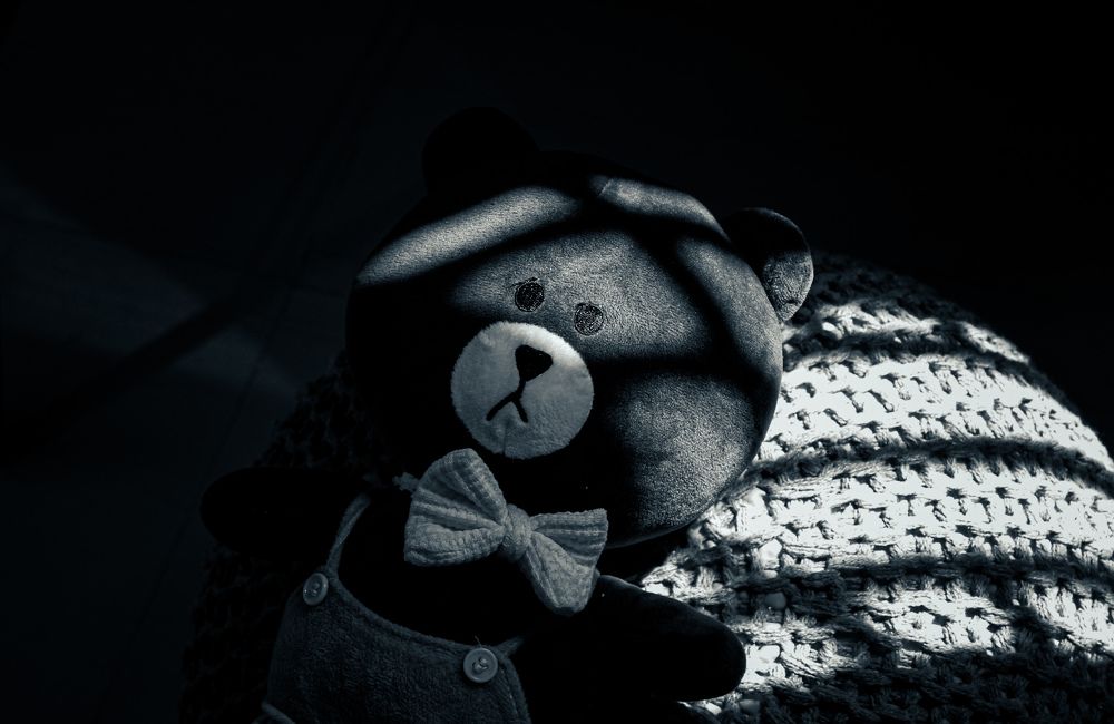 a teddy bear sitting on a blanket