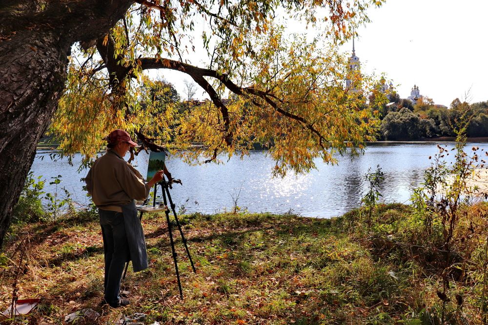 Художница рисует осень.