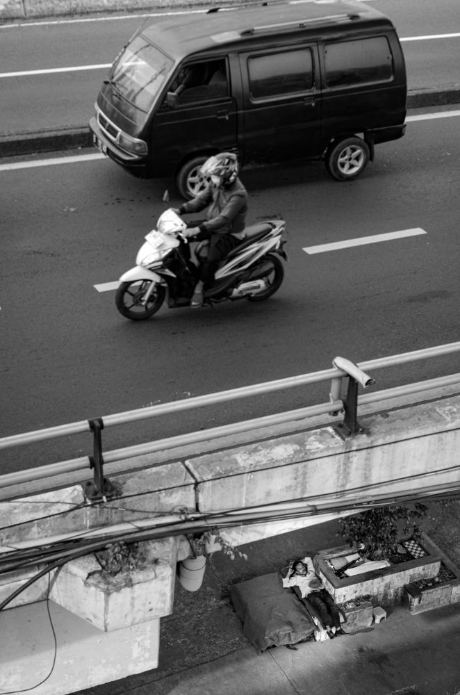 Duality of Urban Life Sleeping Beneath The Bridge, Hustle Above