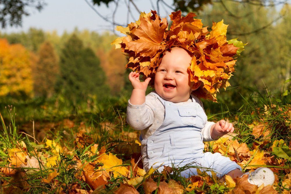 Счастливый малыш венком из осенних листьев