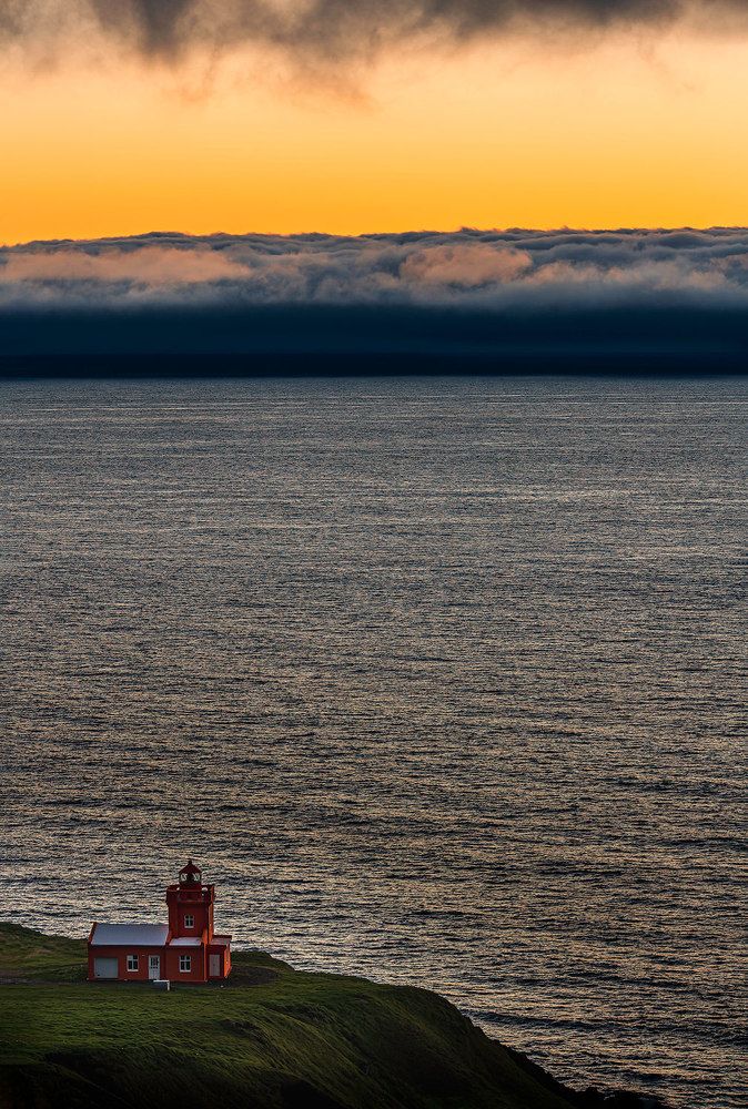 sunset and lighthouse with clouds from coming storm