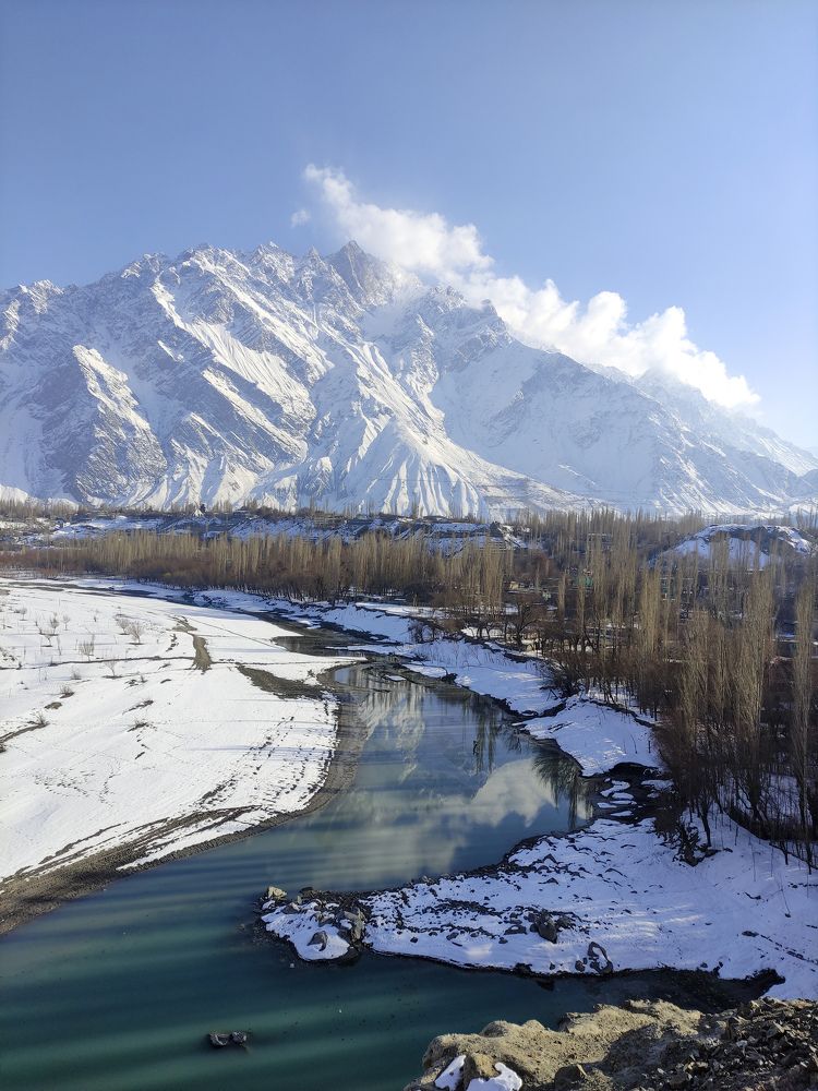 Snow-kissed peaks crowned with clouds