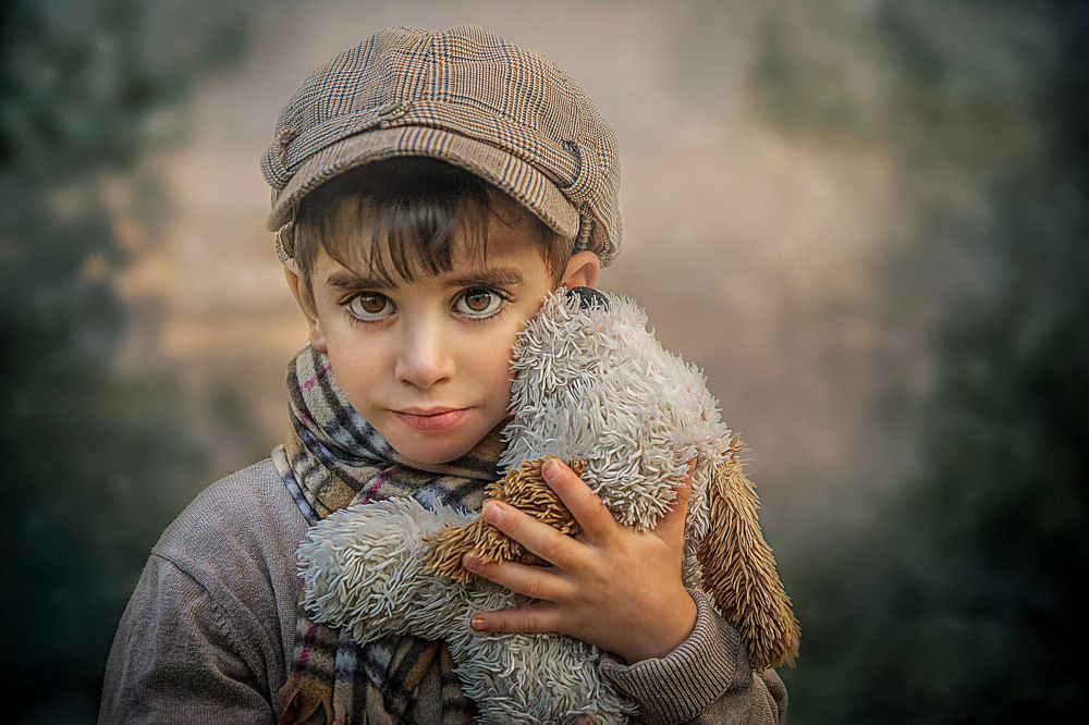 A boy hugs a furry dog ​​doll