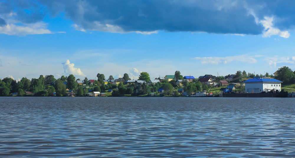 Coastal village of Ivanov Bor on the banks of the Sheksna River on a summer day