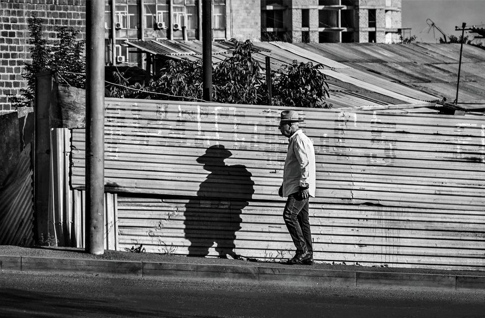 Мужчина в шляпе, идущий вверх по ул. Прошяна