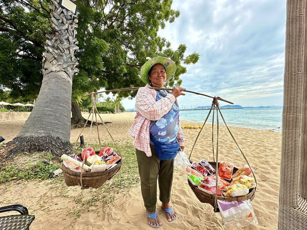 Торгующая фруктами на пляже.