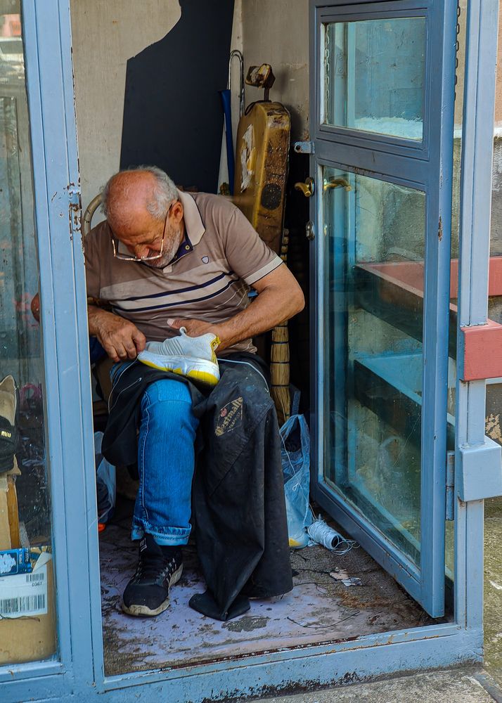 A cobbler, who repairs a sneaker