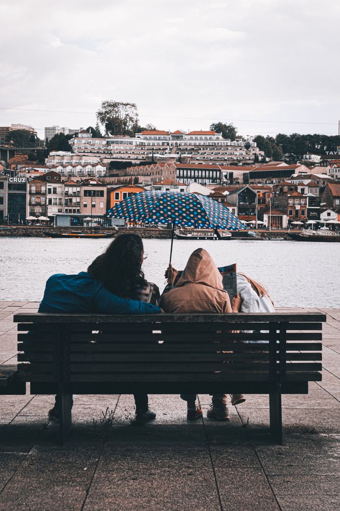 Family sitting on a bench, hiding from the rain.
