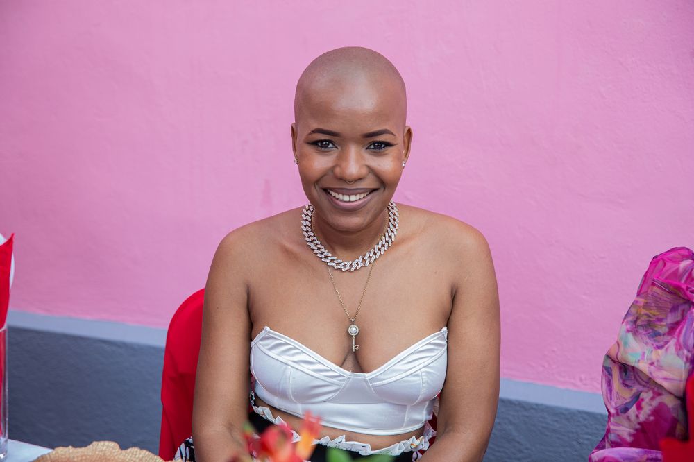 A young woman without hair smiling in a portrait photo.