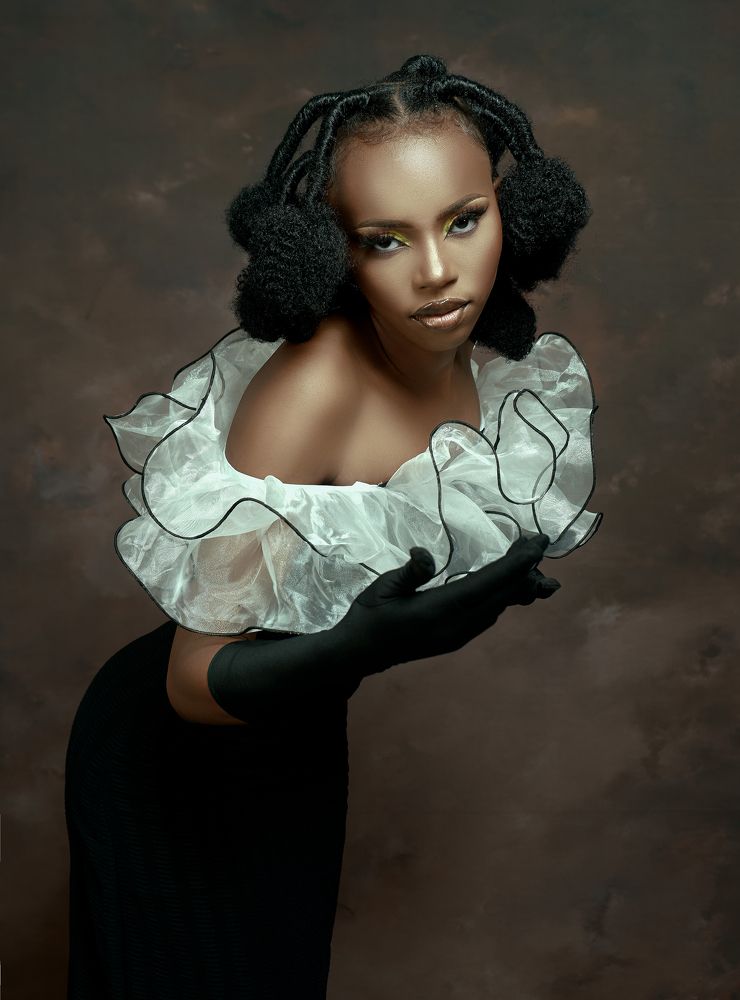 female person, wearing an elegant black dress with a transparent white fabric collar