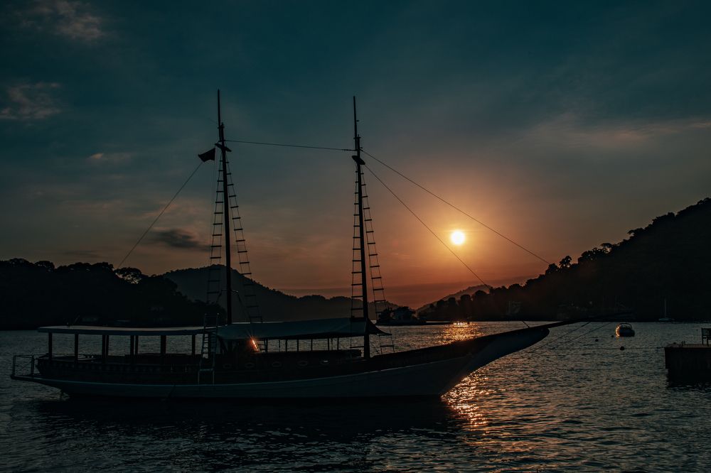 Golden Sunset Over the Bay: A Schooner in Silhouette