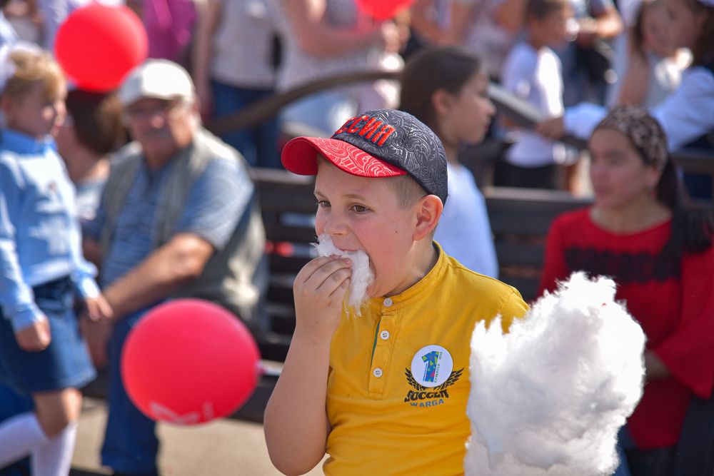 1 Сентября. Первоклассник ест сладкую вату.