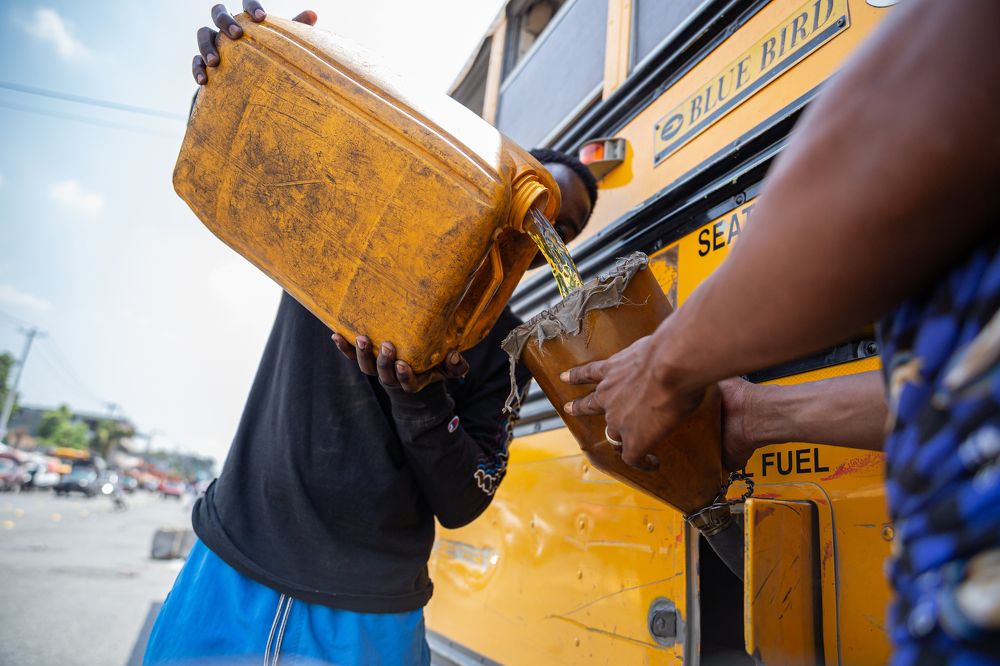 A man puts gasoline in a school bus