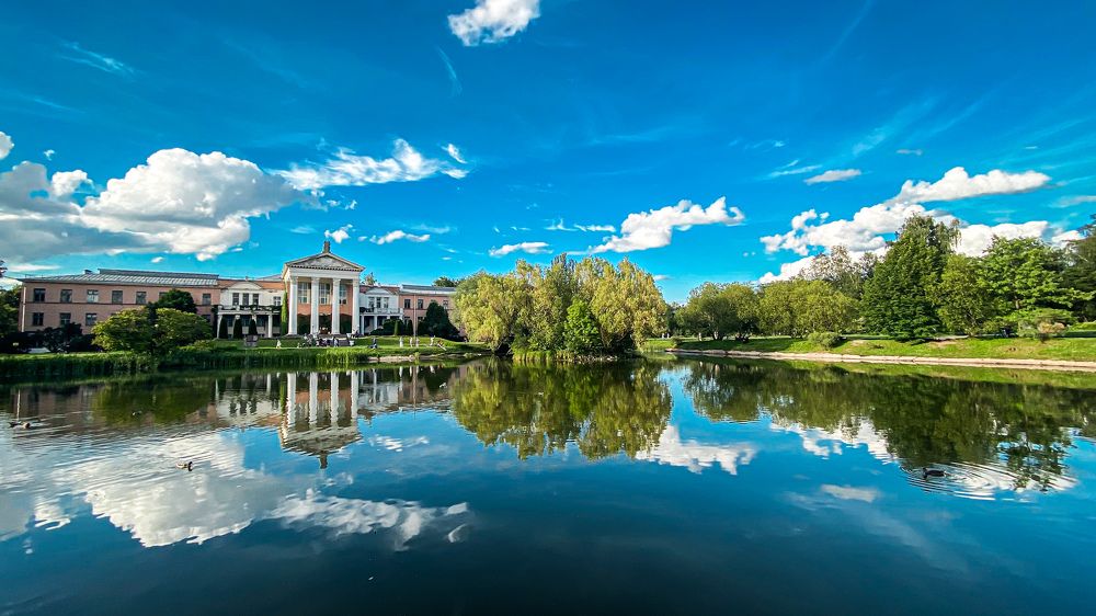 the main building of the botanical garden, a bright blue sky, and a picturesque landscape