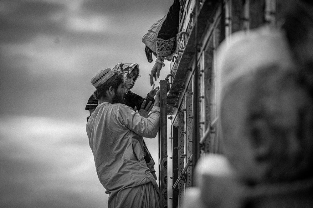 A 4-year-old girl reaches out her tiny index finger to touch her mother's hand, her face a canvas of confusion and innocence.