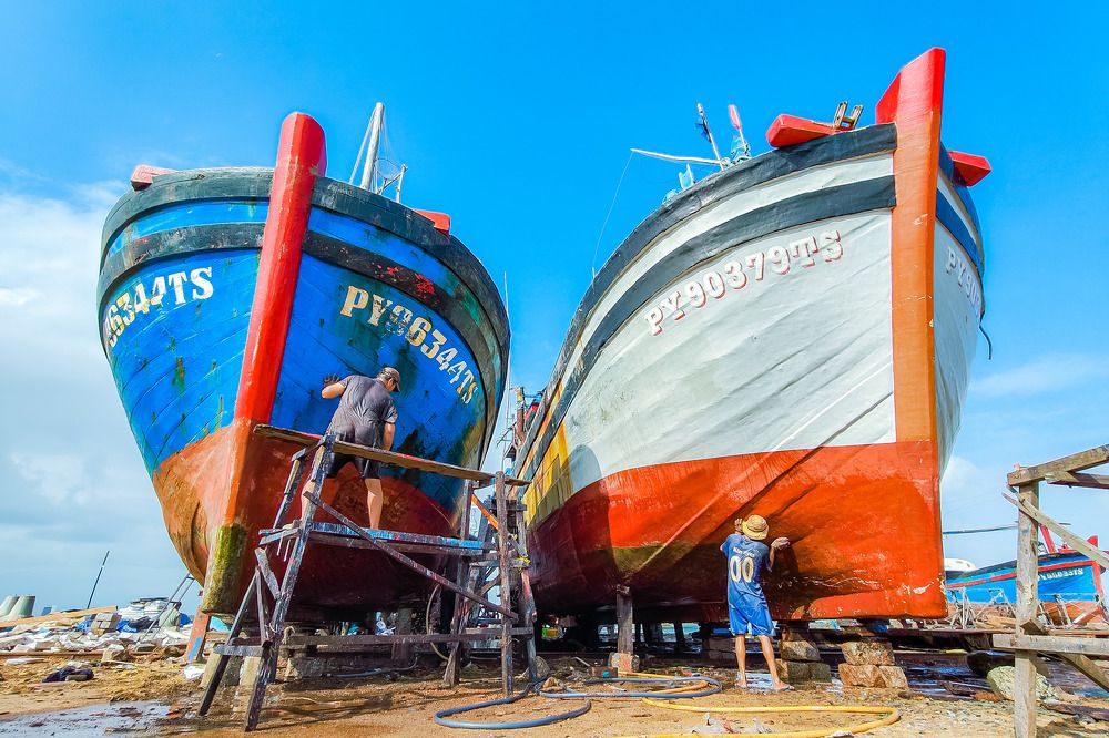 Man Repairing a Fishing Boat