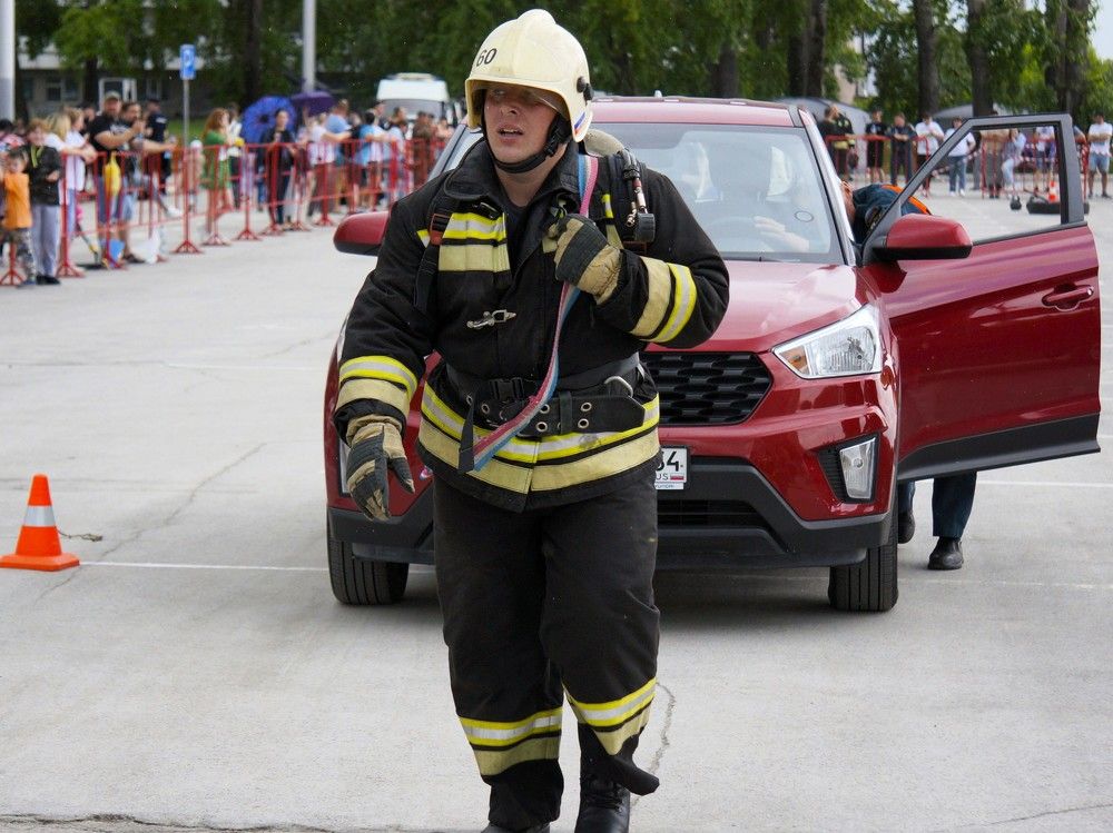 Пожарный на соревнованиях по кроссфиту тянет за собой легковой автомобиль
