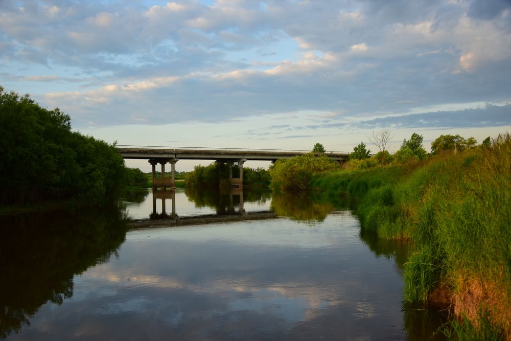 Мост через спокойную реку на рассвете