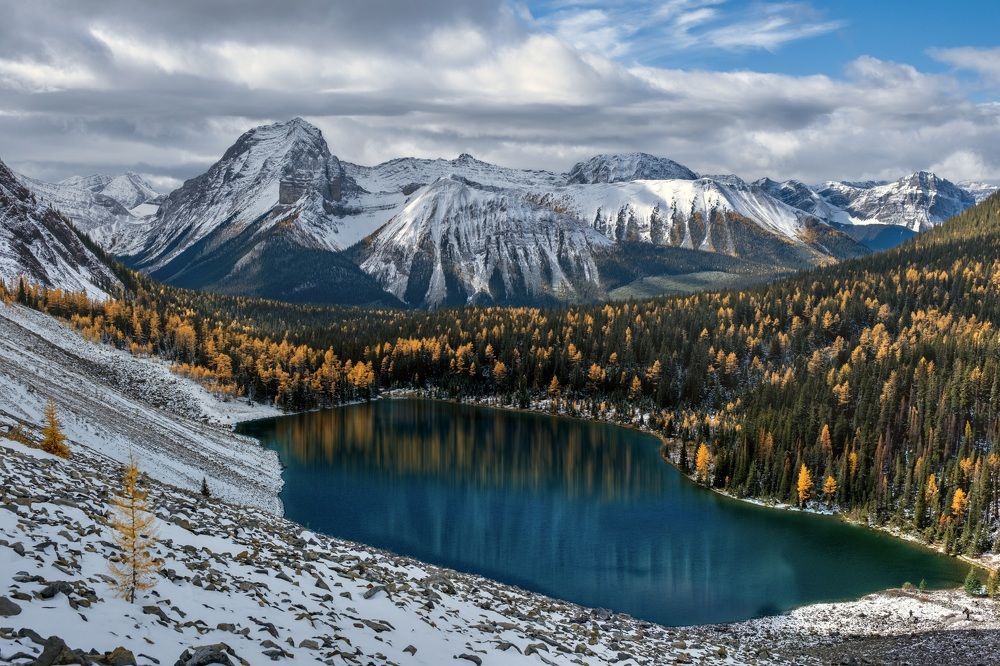 Горное озеро осенью в окружении золотых лиственниц
