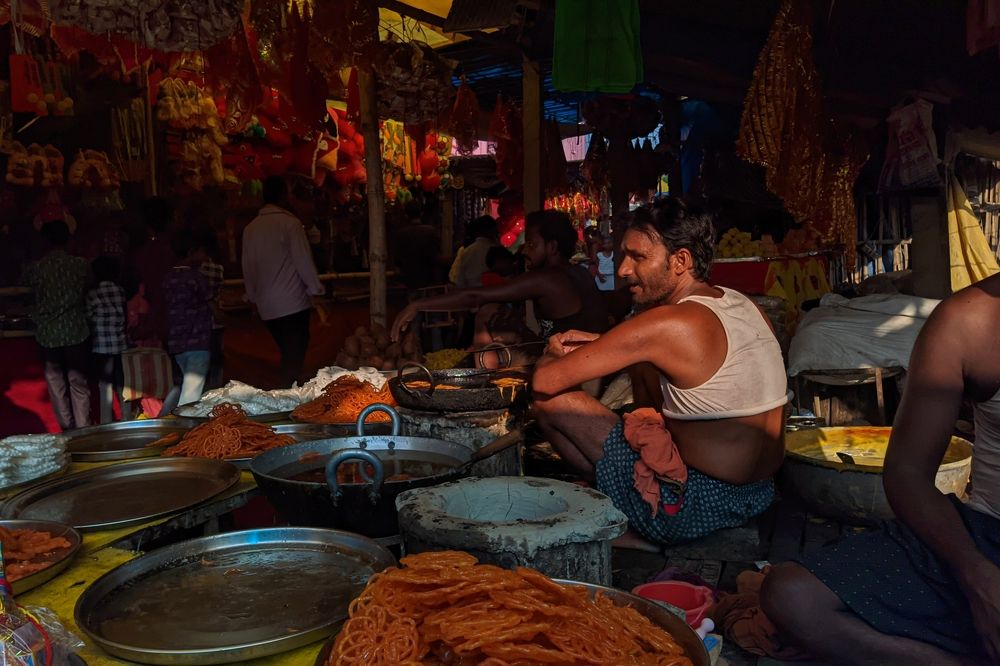 Street Vendor Frying Sweets in a Busy Market