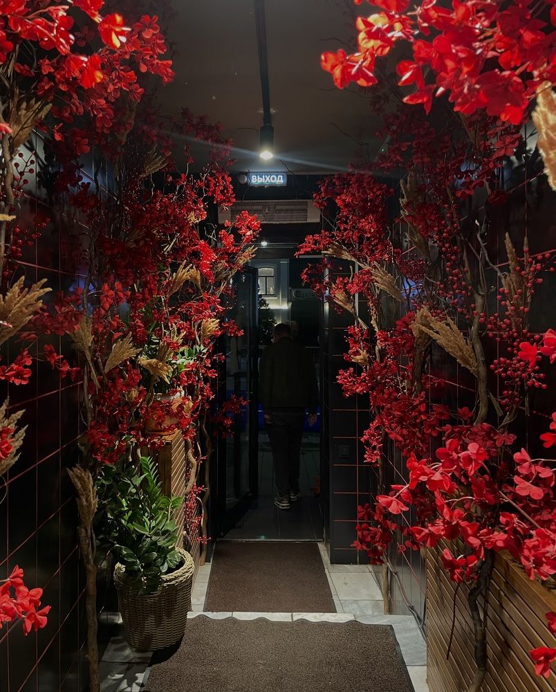 Декор из красных ветвей в темном коридоре