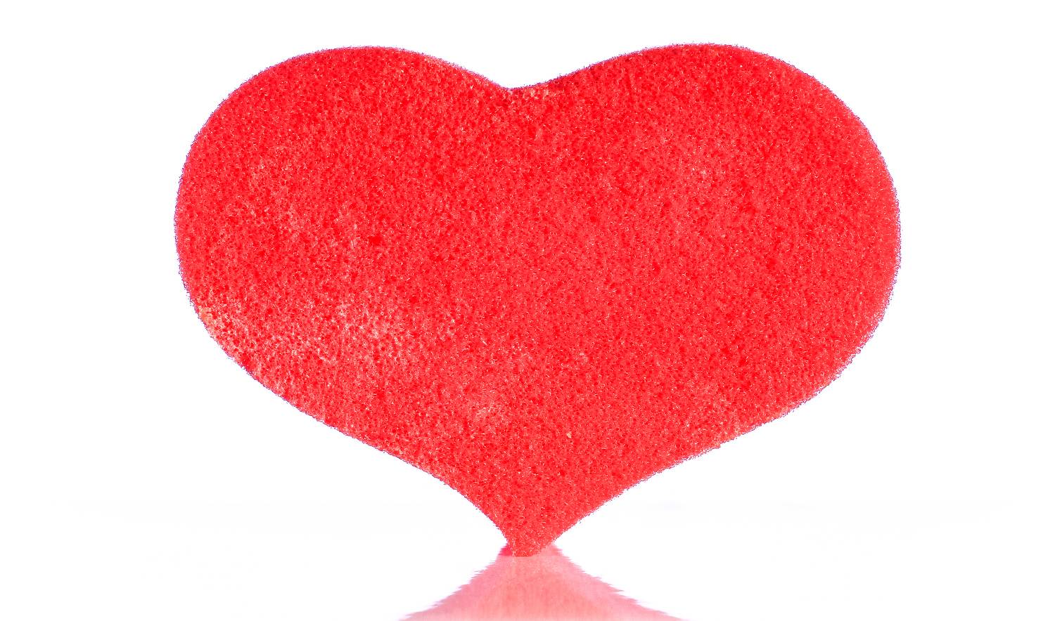 Red heart shaped washcloth on white background